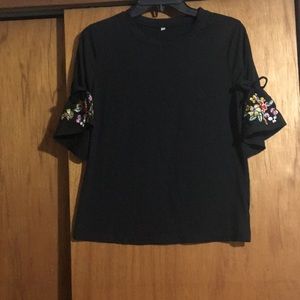 Black shirt with embroidered flower on bell sleeve